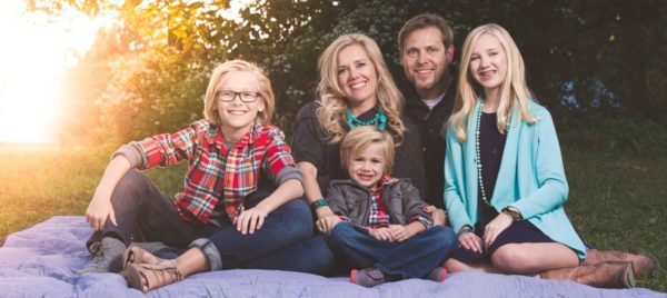 Beautiful adorable blonde family portraits snuggling on a blanket at a park in chesterfield, mo. Whitney, Mark, Ainsley, Rowan, & Harper. Dressed in denim, blues, greys, and red plaids. Late summer, early fall in st. louis missouri